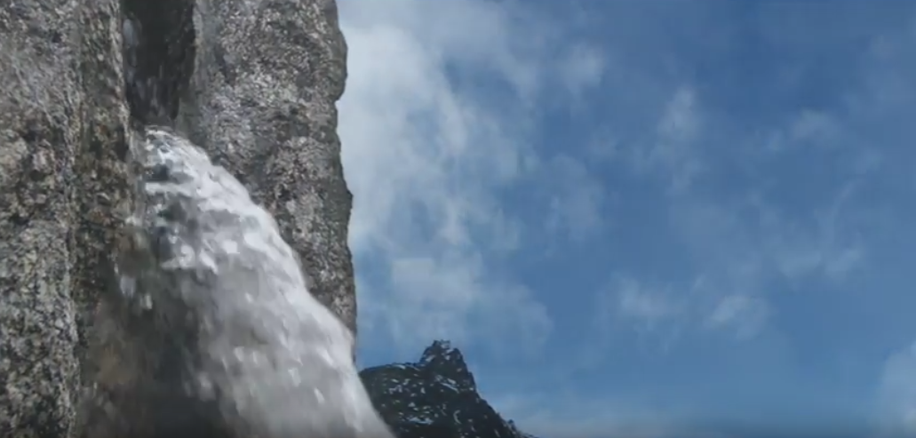 Ein Wasserfall, der aus einer Klippe kommt.