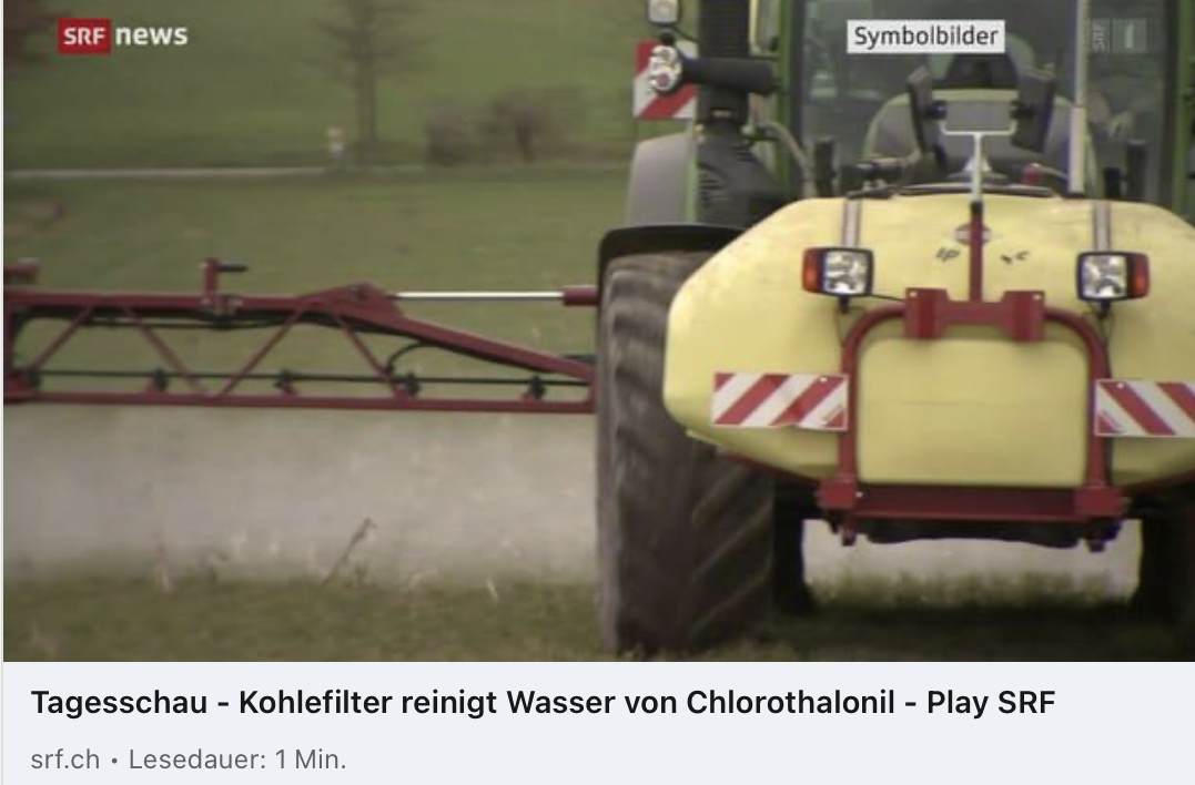 Ein Traktor besprüht ein Feld mit Pestiziden durch einem Sprühgerät.