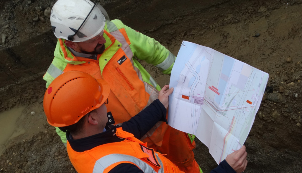 Deux chefs de chantier examinent un plan.