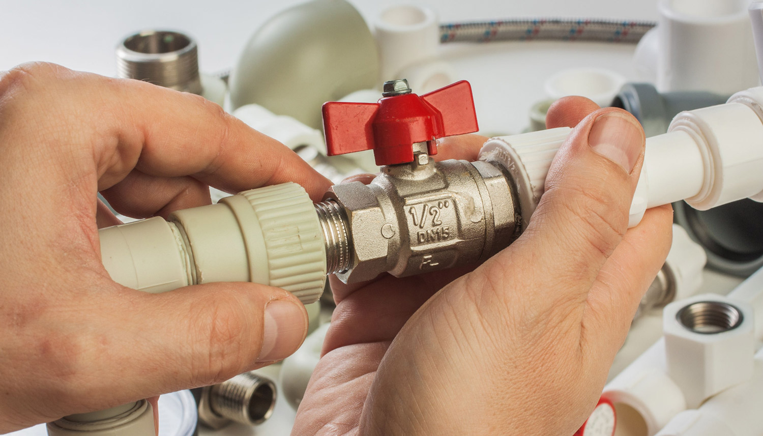 Ein Sanit&auml;rinstallateur arbeitet an einem Sanit&auml;rventil.