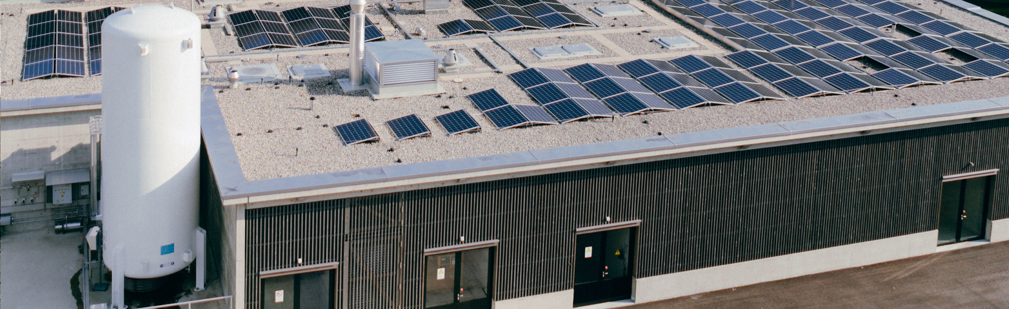 Eine Luftaufnahme eines Gebäudes mit Sonnenkollektoren auf dem Dach.