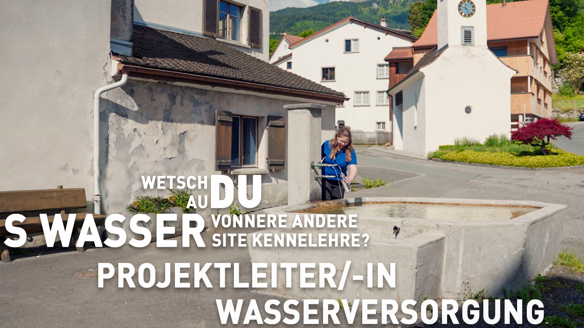 Eine Person füllt eine Flasche an einem öffentlichen Wasserbrunnen auf einem kleinen Dorfplatz mit traditionellen Gebäuden und einem Kirchturm. Ein großer deutscher Text überlagert das Bild.